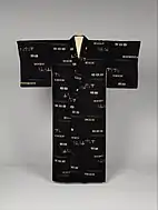 Front view of a women's indigo kimono with a woven ikat pattern in white, cream and brown.