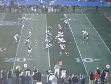 Two football teams on the field in position prior to the play