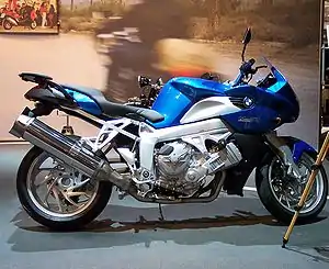 Blue BMW K1200R indoors with a promotional display in the background