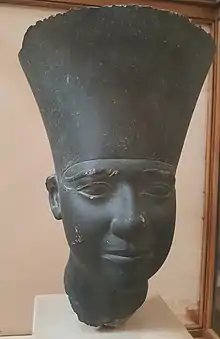 Black statue of a head wearing a large crown