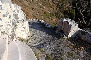 Two separate low walls leading to a corridor.