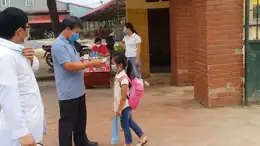 Elementary-school girl having her temperature checked outside a school