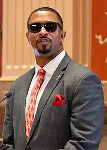 Coleman standing at a podium in 2023