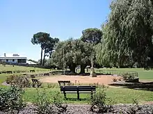 Photograph of a tall war memorial and benches
