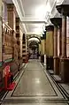 First-floor corridor, with faience tiled walls and terrazzo floor with mosaic border contrasted with the simple white plaster-work ceiling, Victoria Building, University of Liverpool