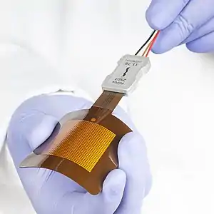 The image shows FHF04, a thin, flexible sensor for measuring heat flux. FHF04SC is a self-calibrating version with an incorporated heater.