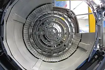 Adour afterburner rear view showing 4 concentric vapour gutters (flameholders) which supply fuel required for minimum boost, the majority of the fuel, known as fill fuel, for full boost comes from 4 concentric manifolds upstream of the gutters to produce flame across the whole afterburner except for cooling air along the duct surface. Also visible is the anti screech liner for preventing pressure fluctuations which can cause damage from overheating.