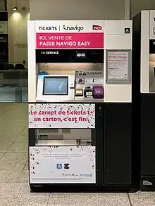 A ticket machine that has a sticker on it announcing that this machine can sell Navigo Easy cards.