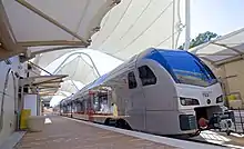 TEXRail Stadler FLIRT waiting on the platform.  DFW Airport Terminal B is a TEXRail terminal station.