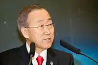 Bespectacled middle-aged man, speaking into two microphones