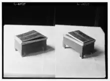 Two, side-by-side monochromatic images of showing three-quarters view of an ornate wooden box inscribed with an Egyptian hieroglyph cartouche.